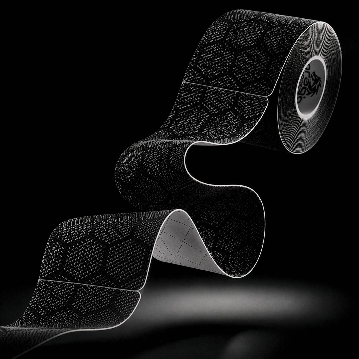 Dragon Tape pro-grade synthetic black kinesiology tape roll and strip with hex pattern.